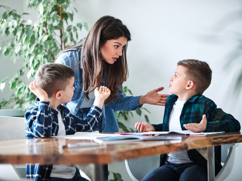 Madre que está haciendo los deberes con sus hijos. Consultoría de AprendEmos.
