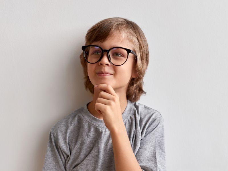 Niño pensativo y sonriendo.