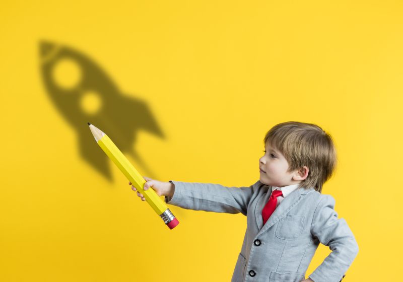 Niño con un lápiz gigante.